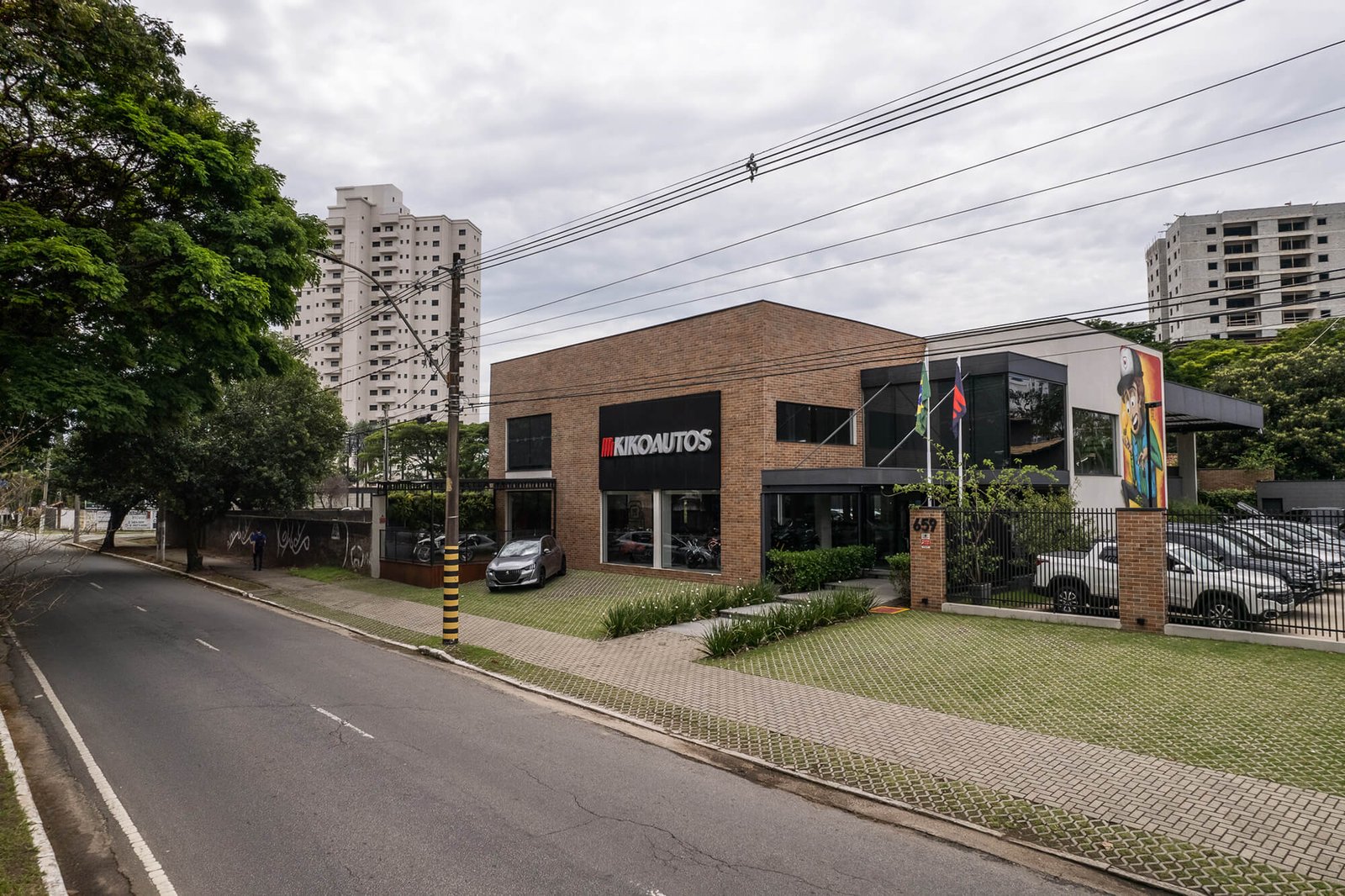 um prédio com estacionamento e carros estacionados na beira da estrada